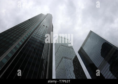 Grattacieli in stormy sfondo con cielo nuvoloso, vista dal basso. Città futuristica con drammatica sky, architettura moderna, concetto di urbanizzazione Foto Stock