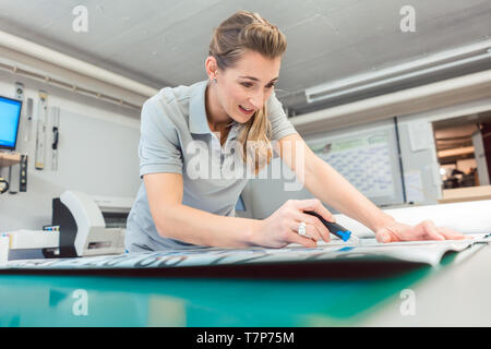 Donna segni di taglio o vinil avvolge la produzione di materiale pubblicitario Foto Stock