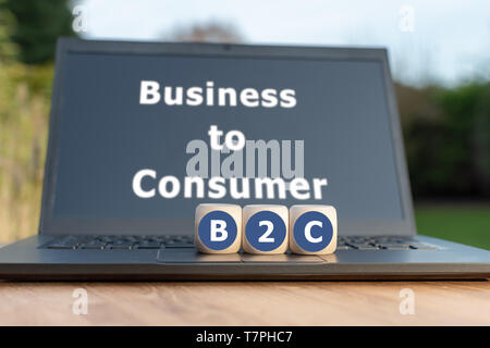 Dadi formano la sigla "B2C'. Dadi posizionati su un notebook. Il testo "Business to Consumer" è scritto sul display. Foto Stock