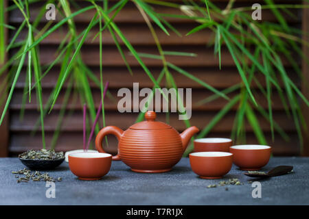 Il tè verde nella teiera e chawan bocce, tazze sullo sfondo di ardesia. Copia dello spazio. Foto Stock