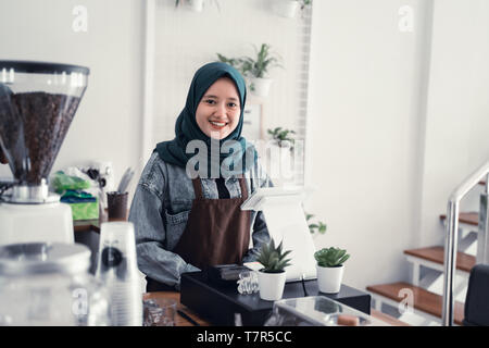 Cameriere musulmana in cafe counter Foto Stock