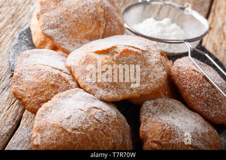 Dolce fritta Bunuelos spolverati con zucchero a velo vicino sul tavolo orizzontale. Foto Stock