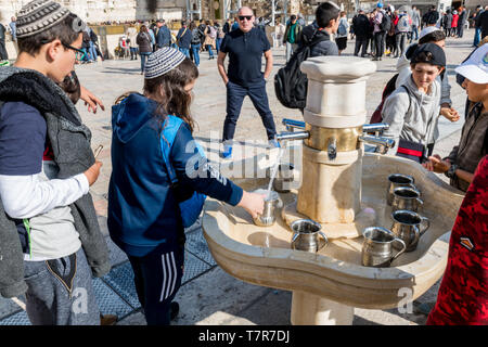 Le gru con acqua e rituale speciale tazze per il lavaggio delle mani accanto al Muro Occidentale di Gerusalemme. Israele. persone lavare le mani Foto Stock
