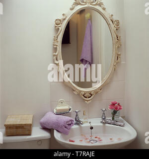 Dipinto di specchio ovale sopra lavandino Foto Stock