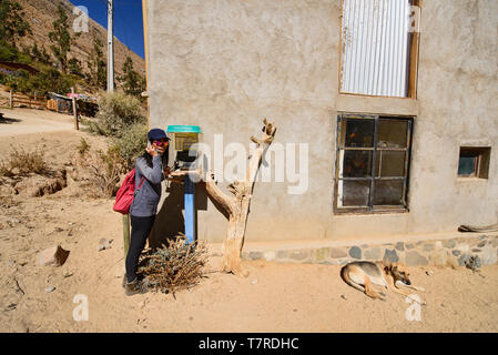 Ourist chiamando da un telefono locale nel villaggio Cochiguaz, Valle Elqui, Cile Foto Stock