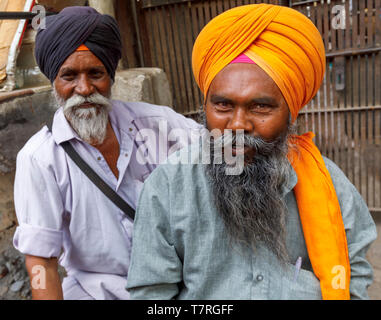 Scena di strada nel quartiere Mahipalpur, un sobborgo vicino all'Aeroporto di Delhi a Nuova Delhi, capitale dell India: due uomini locali, sikh in turbanti Foto Stock