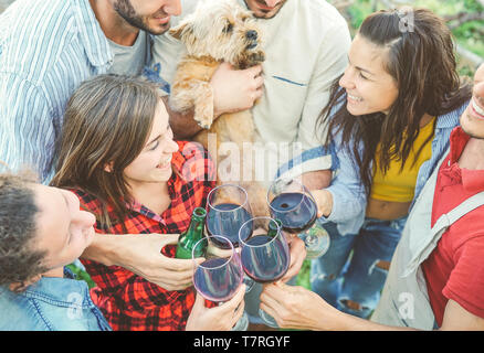 Happy amici tifo con bicchieri di vino rosso outdoor - Giovani avendo divertimento bere, tostatura e ridere insieme in una casa vigna Foto Stock