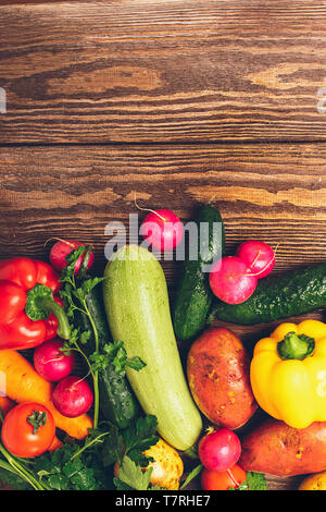 Raccolto freschi maturi Zucchine Ortaggi cetriolo pepe verdi distese su un sfondo di legno. Cibo sano per la mietitura. Foto Stock