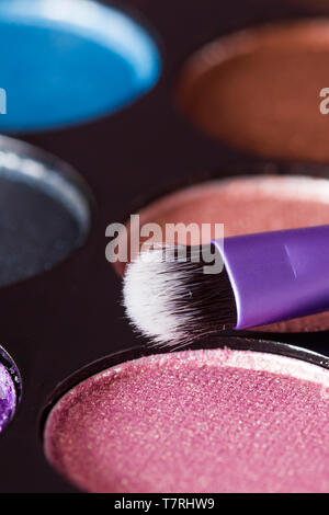 Spazzola per il trucco con il trucco tavolozza in background Foto Stock