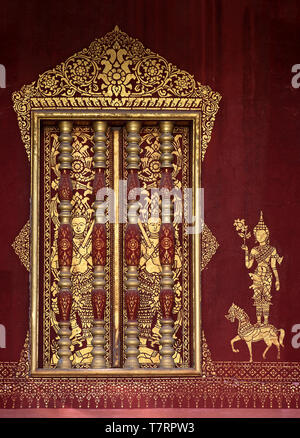 Windows con accenti di Khmer-stile balaustre in legno dorato e murales stencil di una divinità, tempio Wat Sensoukharam, Luang Prabang, Laos Foto Stock