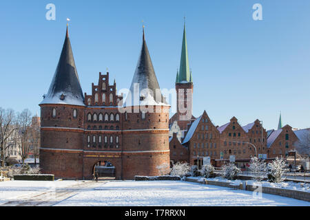 Il Mattone città gotica porta Holstentor/ Holstein Gate nella città anseatica di Lubecca in inverno, Schleswig-Holstein, Germania Foto Stock