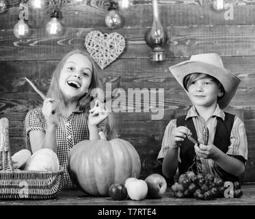 Bambini presentando farm raccolto lo sfondo di legno. Motivi per cui ogni bambino dovrebbe sperimentare l'agricoltura. Mercato di fattoria. I fratelli avendo divertimento. Gli agricoltori per bambini ragazza ragazzo verdure raccolto. Azienda agricola a conduzione familiare. Foto Stock