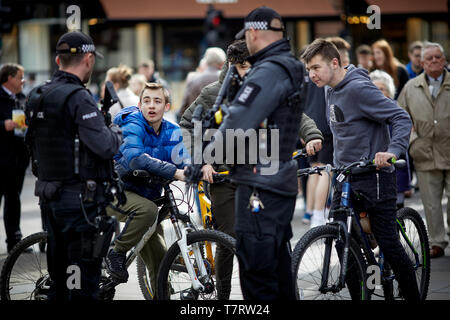 Newcastle upon Tyne, polizia armata sul centro della città a chiacchierare con i ragazzi sul biles Foto Stock