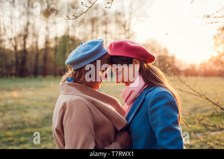 Senior mamma e figlia adulta abbracciando nella foresta di primavera. La festa della mamma concetto. I valori della famiglia Foto Stock