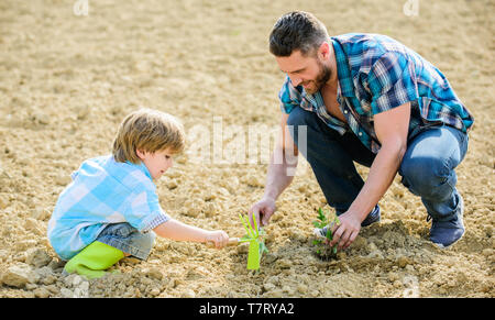 Ricco terreno naturale. Eco farm. nuova vita. suoli e fertilizzanti. piccolo bambino aiutare il padre in agricoltura. padre e figlio piantare fiori in massa. felice giornata della terra. Albero di famiglia. La giornata della terra. Riuscita. Foto Stock