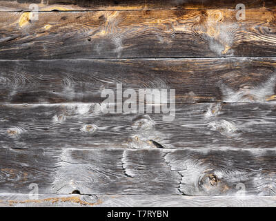 Un muro fatto di vecchi, weathered sbiadito e tavole di legno. Sfondo dal vecchio, pannelli grigio con motivi luminosi. Una parete di un vecchio capannone nel sole luminoso. Foto Stock