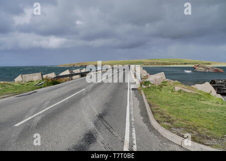 Una strada attraverso una barriera di Churchill in isole di Orkney in Scozia, Regno Unito Foto Stock