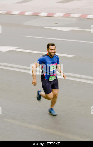 Uomo sorridente e corre veloce come flash, movimento sfocato Foto Stock