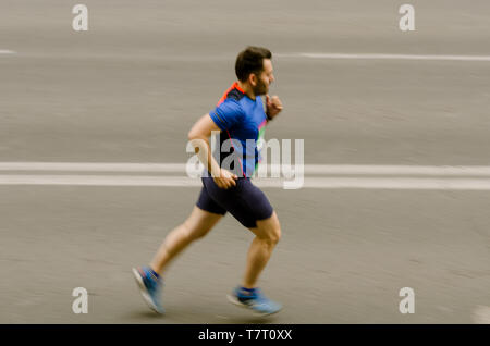 L'uomo corre veloce come flash, movimento sfocato Foto Stock