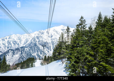 Montagna con neve in villaggi Okuhida Shinhotaka cavo di funivie aeree di alta vista angolare nella Prefettura di Gifu, Giappone park con cielo blu sulla giornata di primavera Foto Stock