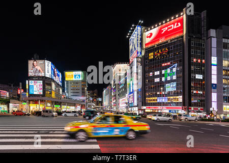 Tokyo, Giappone - Aprile 4, 2019: Shinjuku in centro città con neon luminoso luci di notte con giallo taxi in movimento sfocato Foto Stock