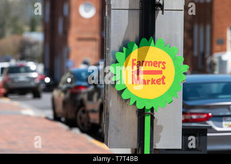 Lexington, Stati Uniti d'America - 18 Aprile 2018: Mercato degli Agricoltori segno con girasole forma con la direzione della freccia nella strada principale della città della Virginia, o città in estate o sp Foto Stock