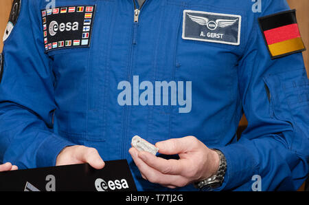 Berlino, Germania. 09 Maggio, 2019. L'astronauta dell'ESA Alexander Gerst (centro) contiene un piccolo pezzo di muro di Berlino dal Mauermusem al Checkpoint Charly. Gerst dalla Bild aveva preso questa con lui verso la ISS. Con lui il pezzo di muro volò intorno alla terra per un anno e mezzo. Oggi lo ha presentato a un rappresentante del Museo Storico Tedesco, dove sarà presto sul display. Credito: Paolo Zinken/dpa/Alamy Live News Foto Stock