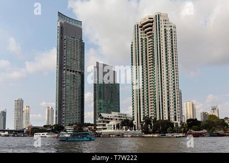 A sinistra il fiume lussuoso condominio, il centro urbano Sathon-Taksin assoluta edificio, diritto Peninsula Hotel presso il fiume Chao Phraya, Khlong Quartiere San Foto Stock