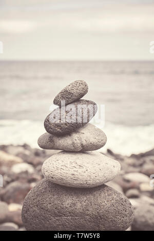 Nei toni del colore dell'immagine di una pila di pietra su una spiaggia, equilibrio e armonia concetto, il fuoco selettivo. Foto Stock