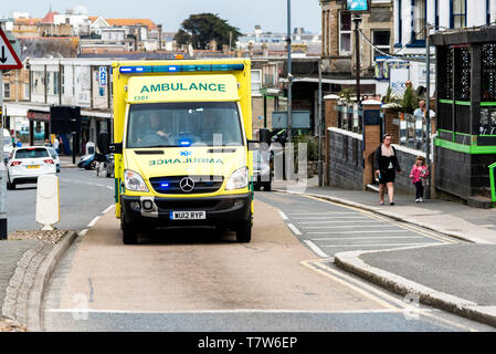 Un'ambulanza NHS con luci blu in risposta a una chiamata d'emergenza a Newquay, in Cornovaglia. Foto Stock