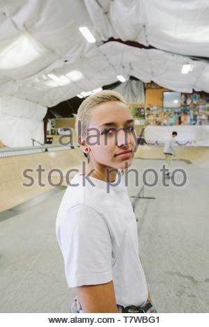 Ritratto fiduciosi, fresco giovane donna a indoor skate park
