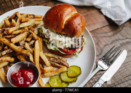 Scalogno dragoncello cheeseburger con Patatine fritte, placcato in qualità di ristorante Foto Stock