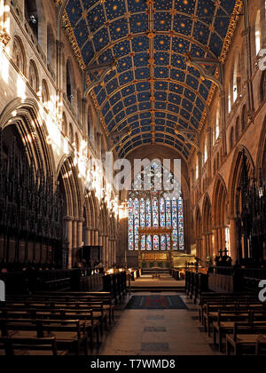 Vista della navata della Cattedrale di Carlisle verso coro medievale-bancarelle & vetro macchiato finestra orientale con intricati blue volta a botte,Cumbria, Inghilterra Foto Stock