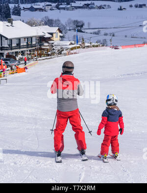 Ragazzo giovane sci con suo padre sulla buona pendenza preparato Foto Stock