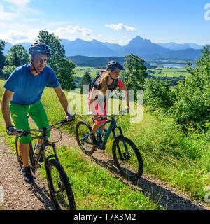 L uomo e la donna sul rilassante gita in bicicletta nelle prealpi vicino Seeg nella parte orientale della regione di Allgäu Foto Stock
