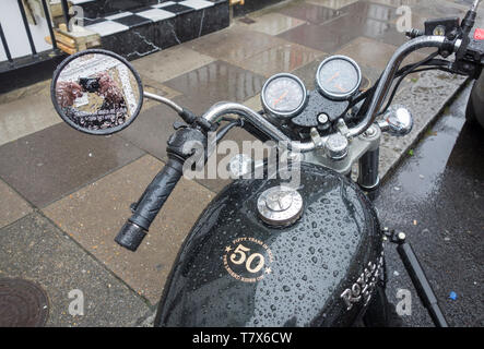 Un classico Royal Enfield Thunderbird stile cruiser moto coperti in gocce di pioggia Foto Stock