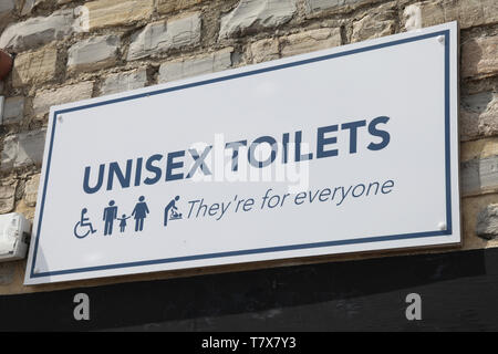 Lyme Regis, Dorset - Unisex wc digital signage sul muro di pietra di sfondo, 2019 Foto Stock