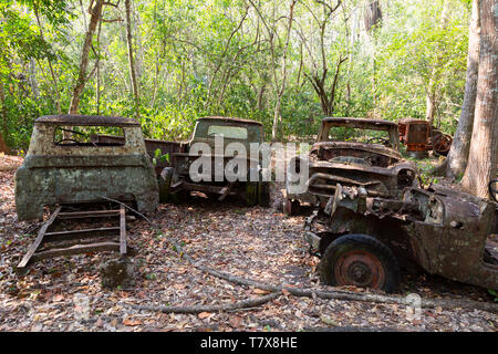 Vecchia auto si arrugginiscano e oggetto di dumping nella foresta, Guatemala America centrale. Concetto - ripartiti, inquinamento, Foto Stock