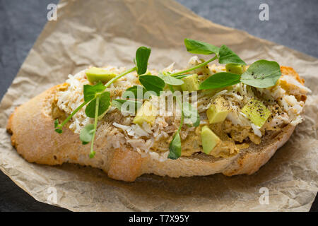 Un sandwich aperto realizzato dal marrone e le carni bianche di un ragno granchio di mare catturati in un calo netto che era stato abbassato off di un molo nel Dorset. La carne di colore marrone h Foto Stock