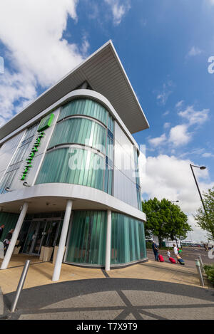 Una famiglia di testa di passeggeri verso Londra Southend Airport dall'Holiday Inn Hotel, Southend on Sea, Essex, Regno Unito. Air Travel accommodation Foto Stock