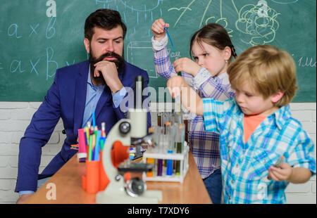 Microscopio strumento ottico a scienza classe. torna a scuola. bambini felici insegnante. Imparare mediante microscopio a scuola lezione. Inizio dello sviluppo dei bambini. Cordiali figli in laboratorio Foto Stock