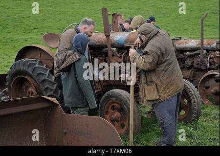 Persone esaminando i trattori e vintage macchinari agricoli in vendita presso un'azienda asta superiore Fattoria Venn, Herefordshire Foto Stock