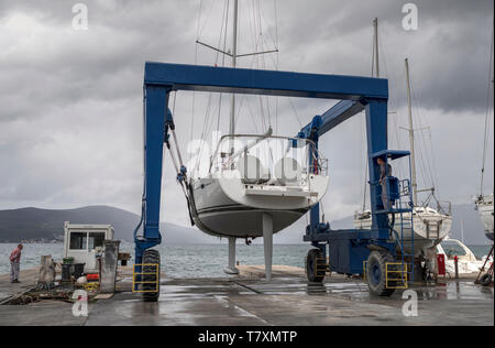 Tivat, Montenegro, 29 Aprile 2019: yacht a vela di trasportare in mare dopo la riparazione da marina gru mobile. Foto Stock