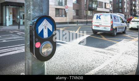 Dublino, Irlanda - 11 Febbraio 2019: il pulsante per attivare il passaggio pedonale sulla strada su un attraversamento pedonale nel centro della città in un giorno di inverno Foto Stock