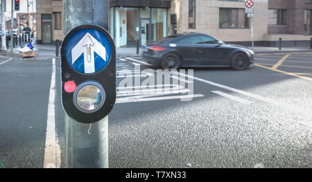 Dublino, Irlanda - 11 Febbraio 2019: il pulsante per attivare il passaggio pedonale sulla strada su un attraversamento pedonale nel centro della città in un giorno di inverno Foto Stock