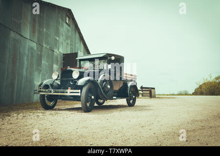 Vecchia auto parcheggio nella parte anteriore di un fienile Foto Stock