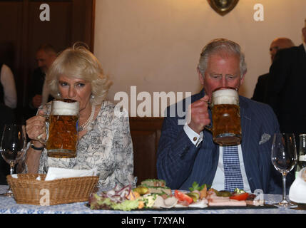 Il Principe di Galles e la duchessa di Cornovaglia prendere un drink da beer steins durante una visita ad una tradizionale sala da ballo e hofbrauhaus (birra hall) di Monaco di Baviera, Germania. Foto Stock