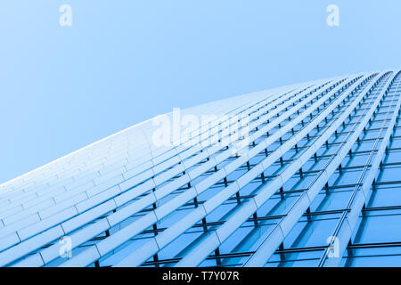 Abstract architettura commerciale un frammento, un muro fatto di metallo e di vetro lucido sotto il cielo blu Foto Stock