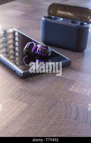 Gli auricolari dello smartphone con connessione Bluetooth in colore nero Foto Stock