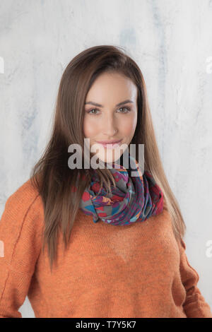 Bella donna in arancione maglione e sciarpa Foto Stock